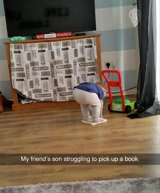 a kid picking up a book